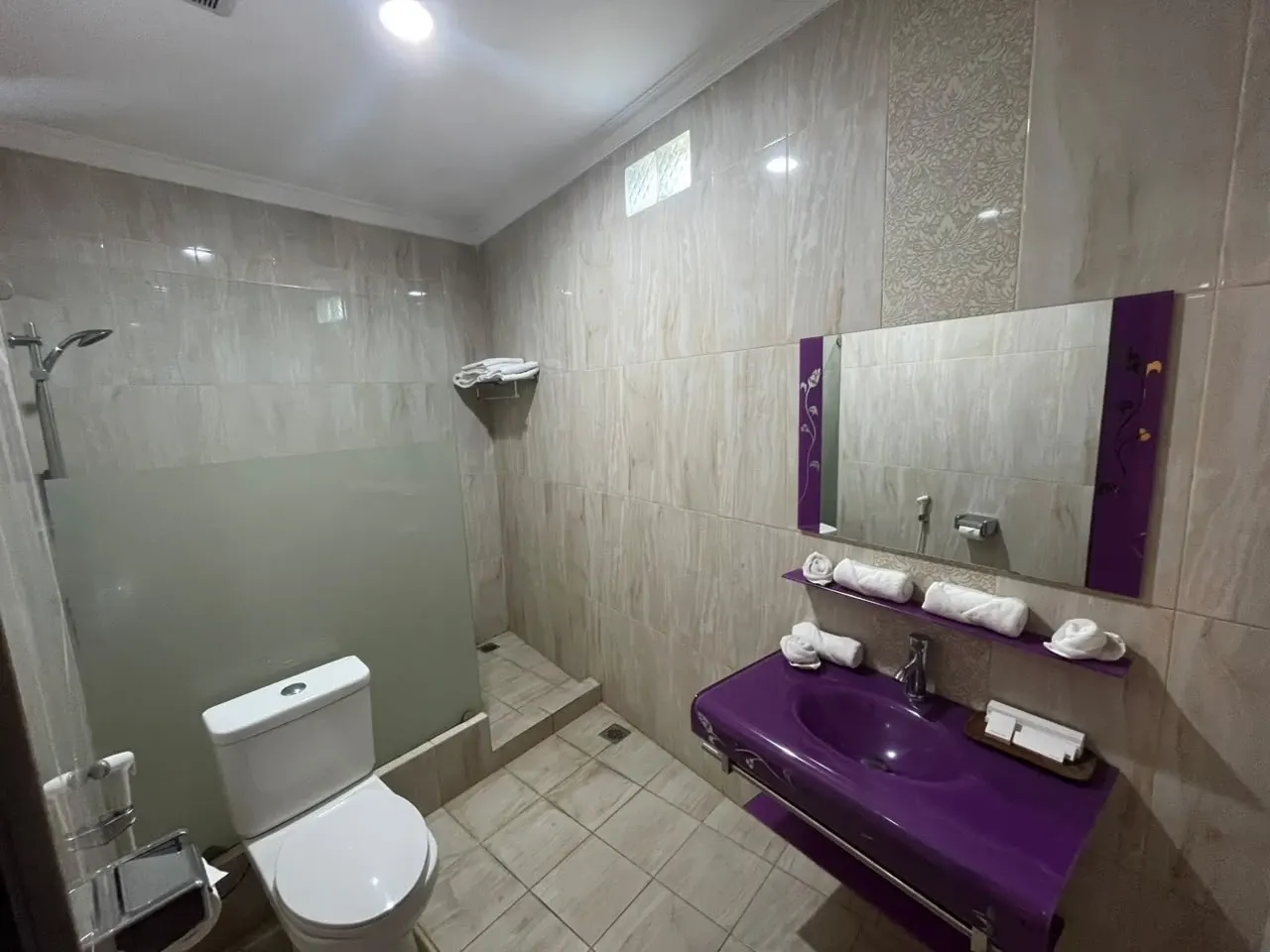 Kamar mandi Deluxe Triple dengan wastafel ungu dan shower.